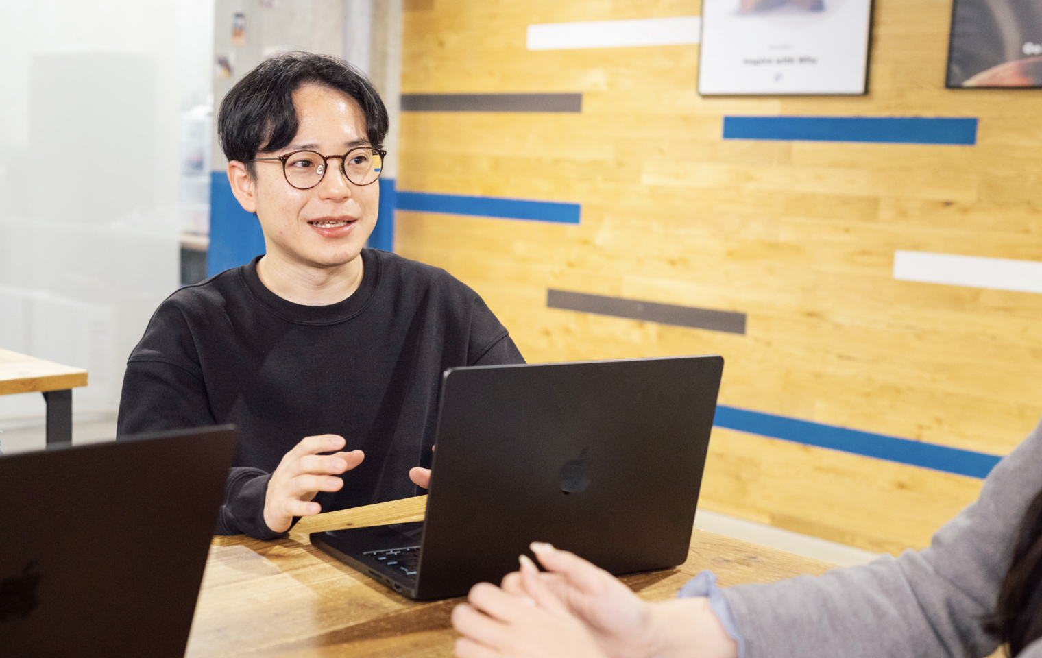 社員が人事担当者と向かい合い、笑顔で面談をしている様子。ノートパソコンを開いて会話している。